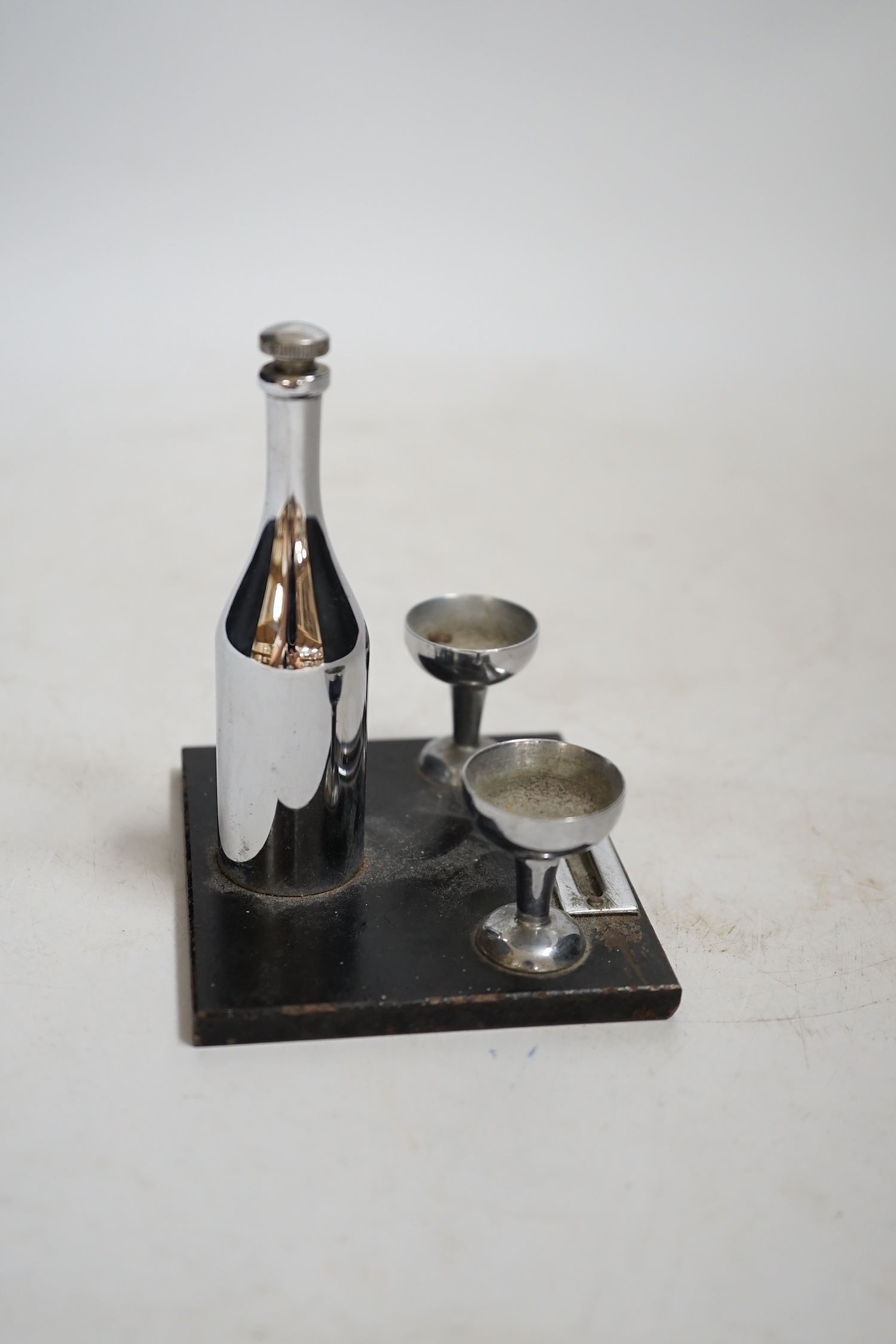 Two Art Deco match strikes, one in the form of a champagne bottle and two glasses, largest 13cm wide. Condition - fair